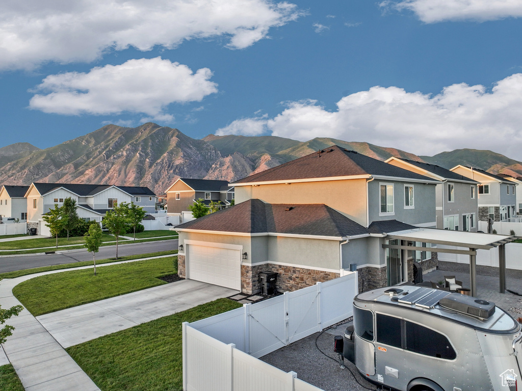 View of front of house with a gate, a residential view, a mountain view, and stone siding