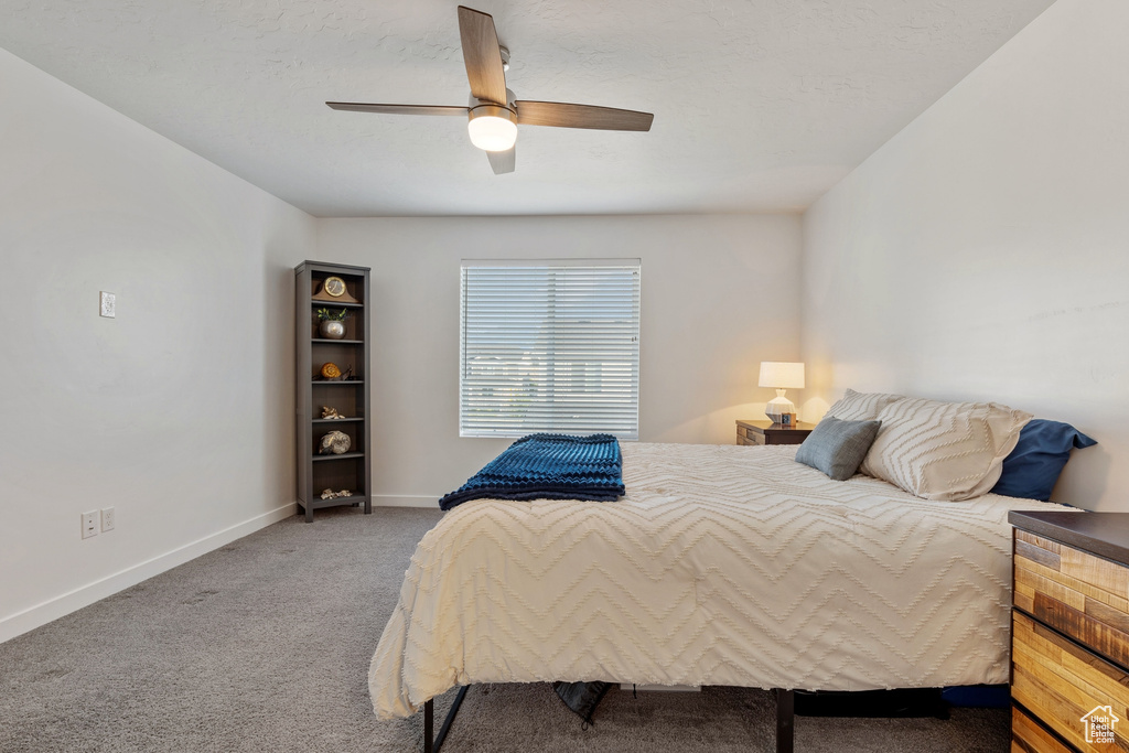 Carpeted bedroom featuring baseboards and a ceiling fan