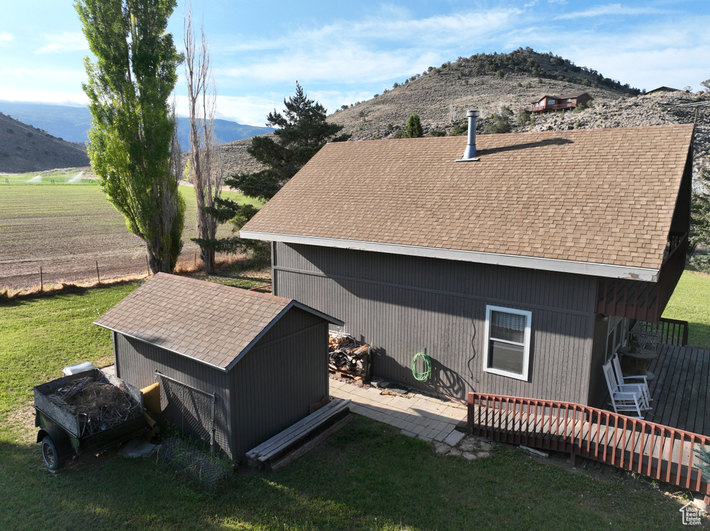 View of home\'s exterior with a mountain view, a shingled roof, a yard, and cooling unit