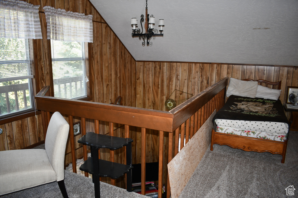 Stairs featuring wood walls, lofted ceiling, a chandelier, and carpet flooring