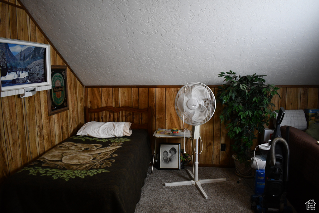 Bedroom with wooden walls and carpet floors