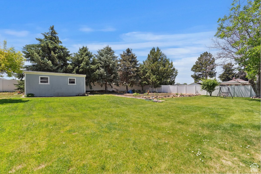 Fenced backyard featuring an outbuilding