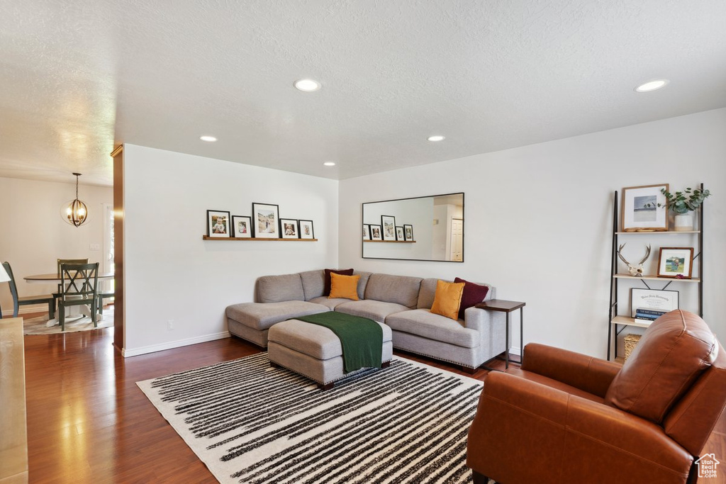 Living area with wood finished floors, a chandelier, recessed lighting, and a textured ceiling