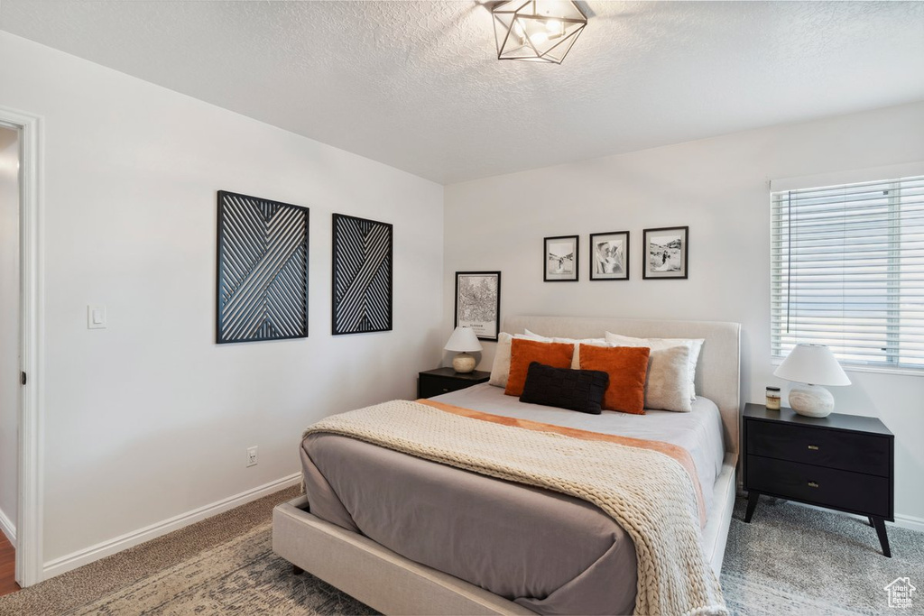 Bedroom featuring carpet and a textured ceiling