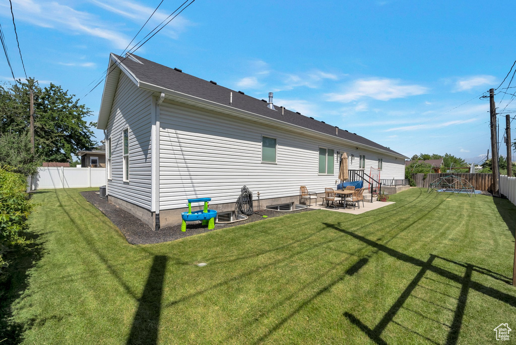 Rear view of house featuring a fenced backyard and a patio