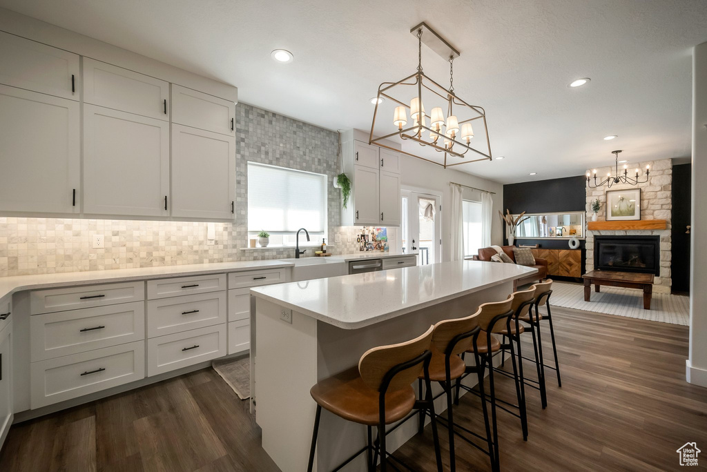 Kitchen with a chandelier, white cabinets, backsplash, dark wood-style flooring, and recessed lighting