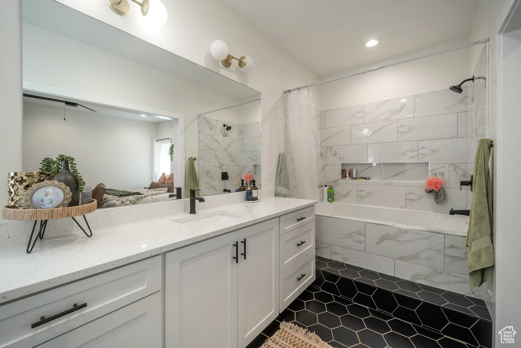 Bathroom featuring tiled shower / bath combo, vanity, tile patterned flooring, and recessed lighting