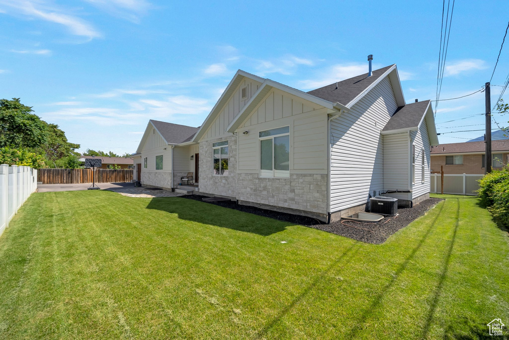 Rear view of property with board and batten siding and a fenced backyard