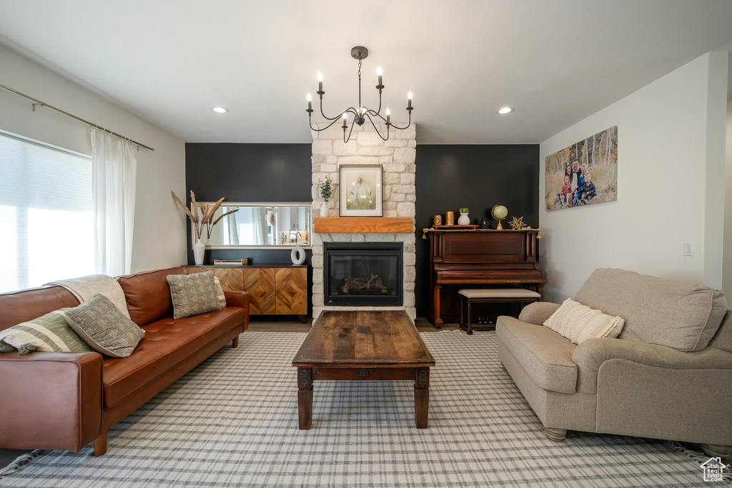 Living room with a chandelier, a stone fireplace, carpet floors, and recessed lighting
