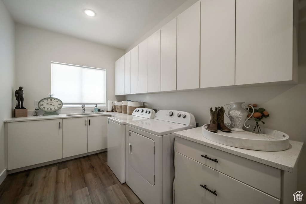 Washroom featuring separate washer and dryer, cabinet space, wood finished floors, and recessed lighting