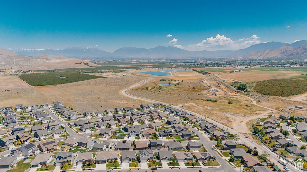 Aerial view of property and surrounding area with a mountainous background and nearby suburban area