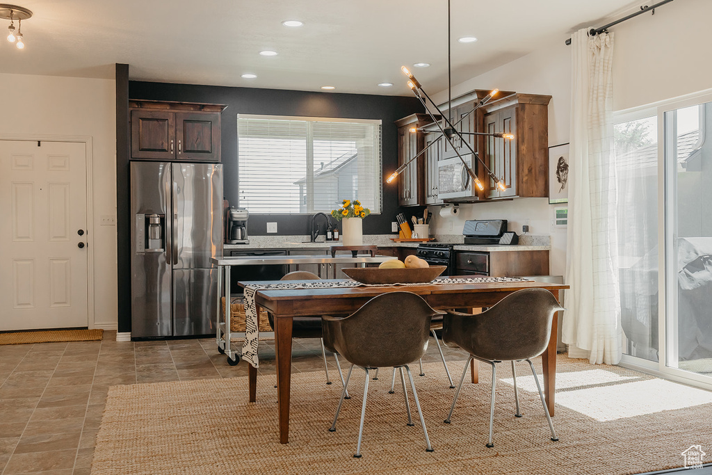 Kitchen with stainless steel appliances, light countertops, healthy amount of natural light, recessed lighting, and dark brown cabinets