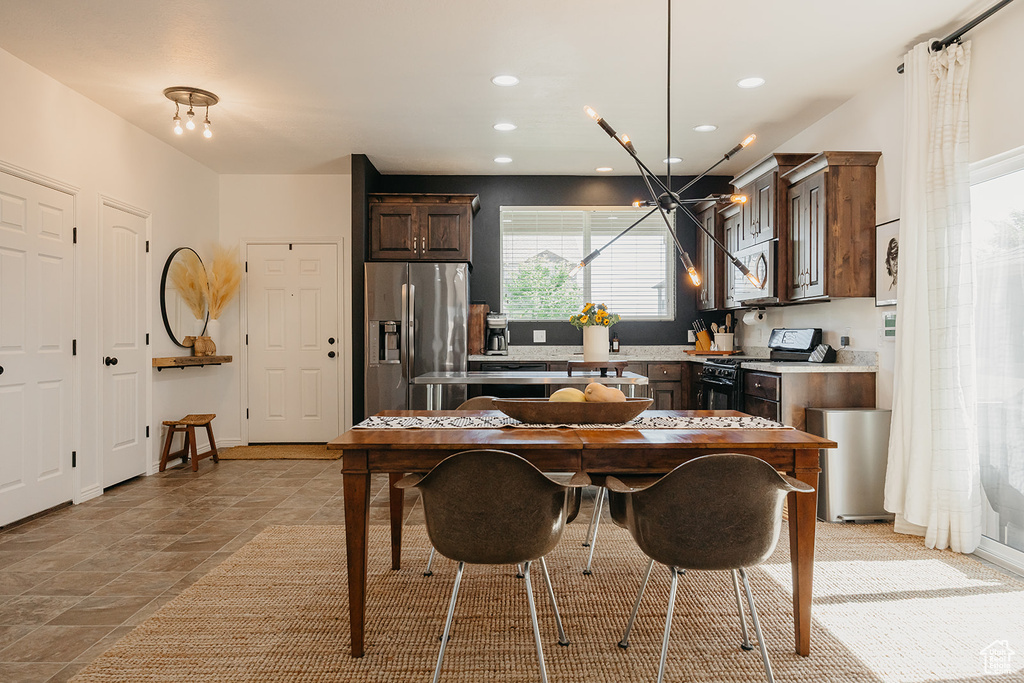 Kitchen featuring appliances with stainless steel finishes, dark brown cabinets, recessed lighting, a chandelier, and light countertops