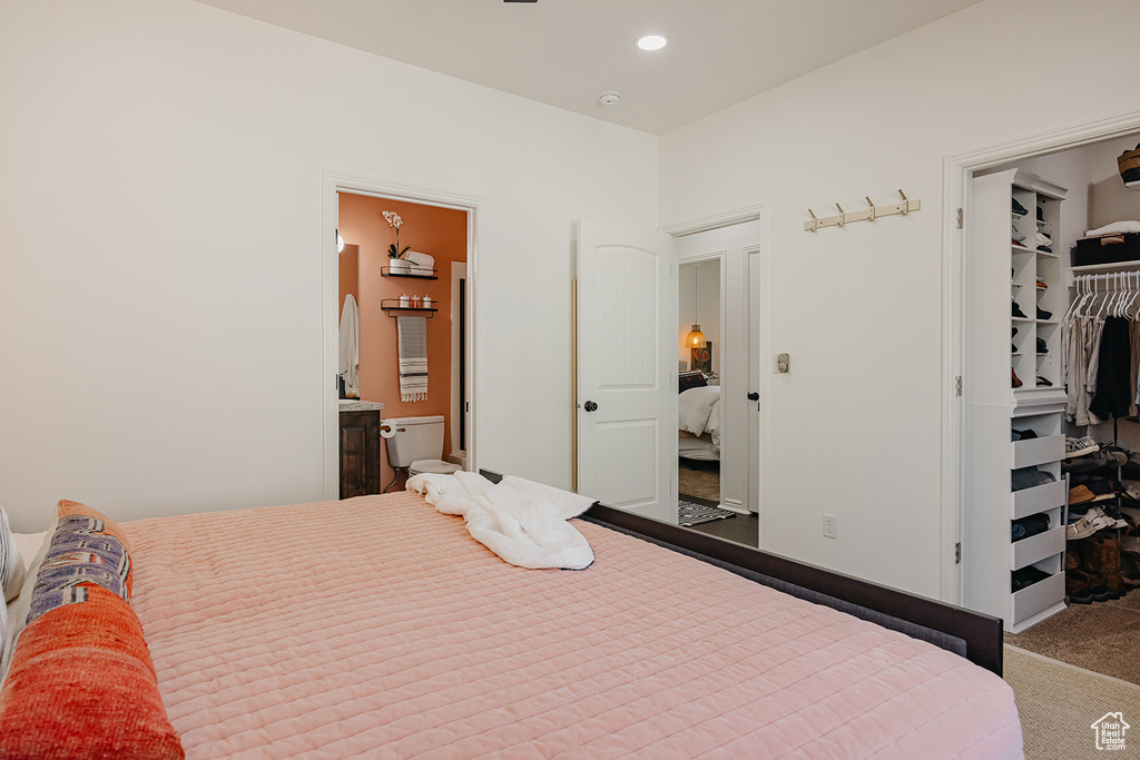 Carpeted bedroom featuring a walk in closet, a closet, ensuite bathroom, and recessed lighting