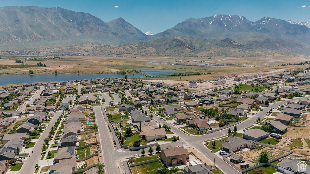 Aerial view of property's location with a water and mountain view and nearby suburban area