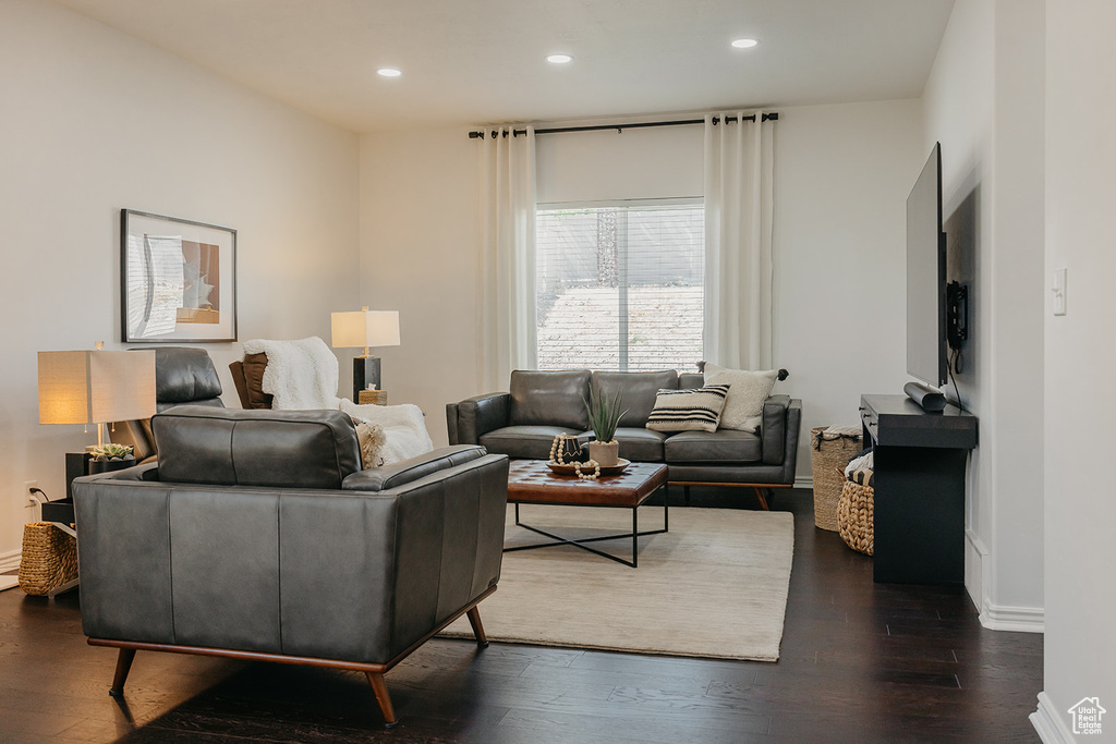 Living area featuring dark wood-type flooring and recessed lighting