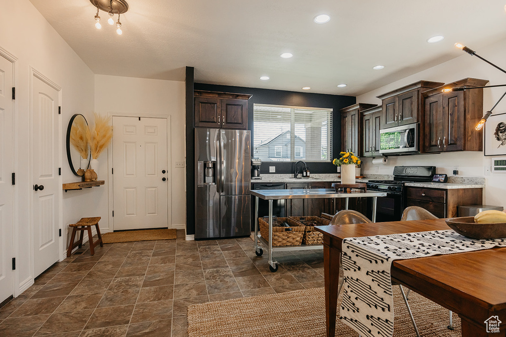 Kitchen featuring black appliances, dark brown cabinets, light countertops, recessed lighting, and dark stone finish flooring