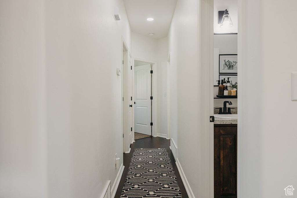 Corridor featuring a sink and baseboards