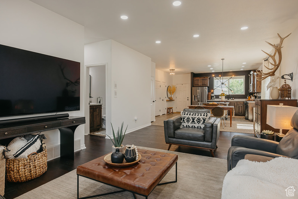 Living room featuring wood finished floors, recessed lighting, and a chandelier