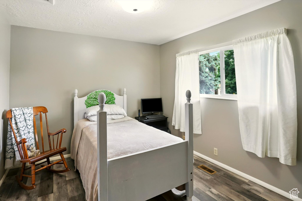 Bedroom with baseboards and dark wood-style flooring
