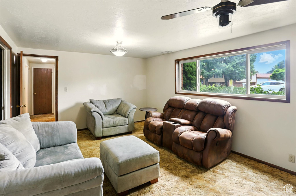 Living room featuring a ceiling fan and carpet flooring