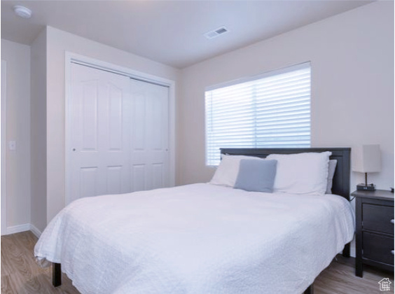 Bedroom featuring wood finished floors and a closet