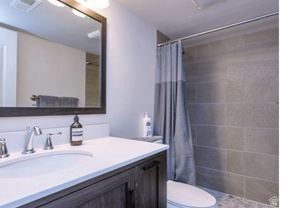Bathroom with tiled shower and vanity