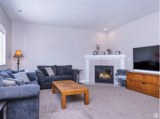 Carpeted living room with a tile fireplace