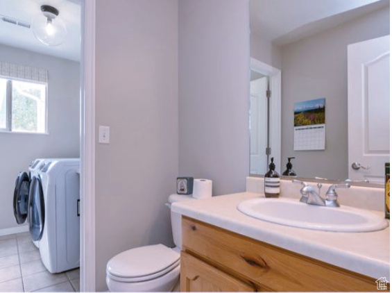 Bathroom featuring washer and dryer, vanity, and tile patterned floors