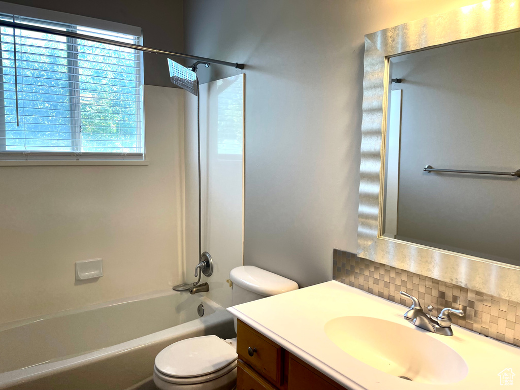 Bathroom featuring vanity, backsplash, and shower / bath combination