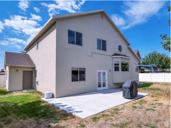 Rear view of property with a patio, stucco siding, and french doors
