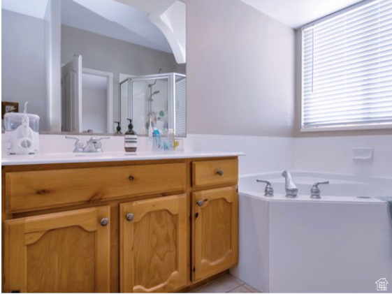 Full bathroom with vanity, a stall shower, a bath, and tile patterned floors