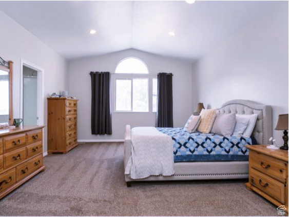 Bedroom featuring carpet and vaulted ceiling