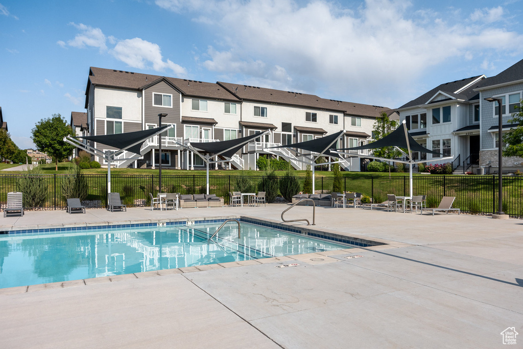 Community pool with a patio and a residential view