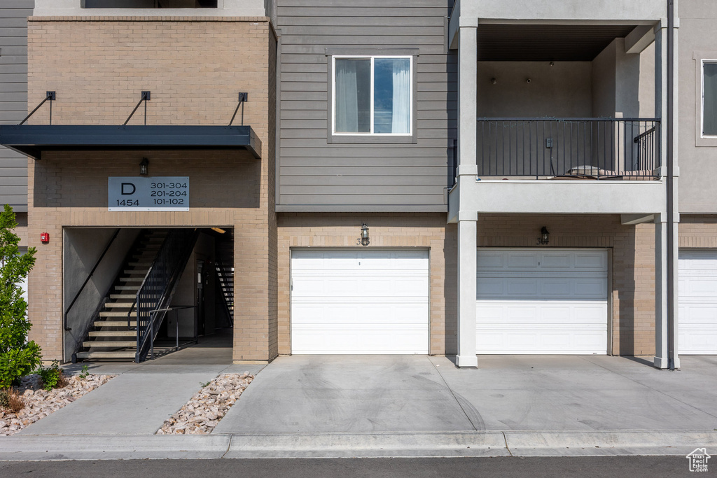 View of building exterior with an attached garage and driveway