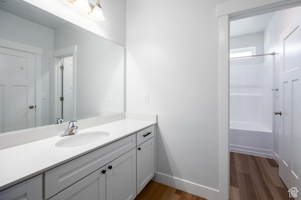 Full bathroom featuring vanity, wood finished floors, and bathtub / shower combination