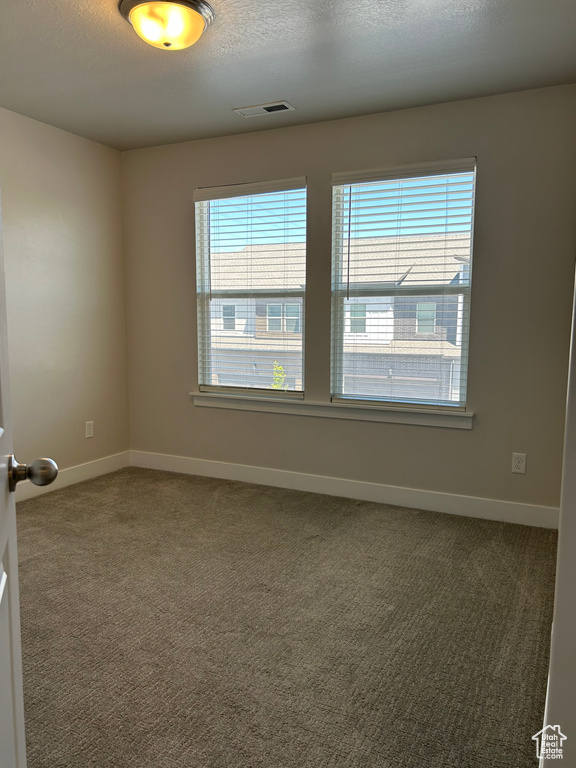 Empty room featuring carpet flooring and baseboards