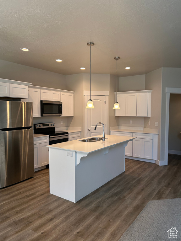 Kitchen featuring appliances with stainless steel finishes, a sink, white cabinetry, light countertops, and recessed lighting