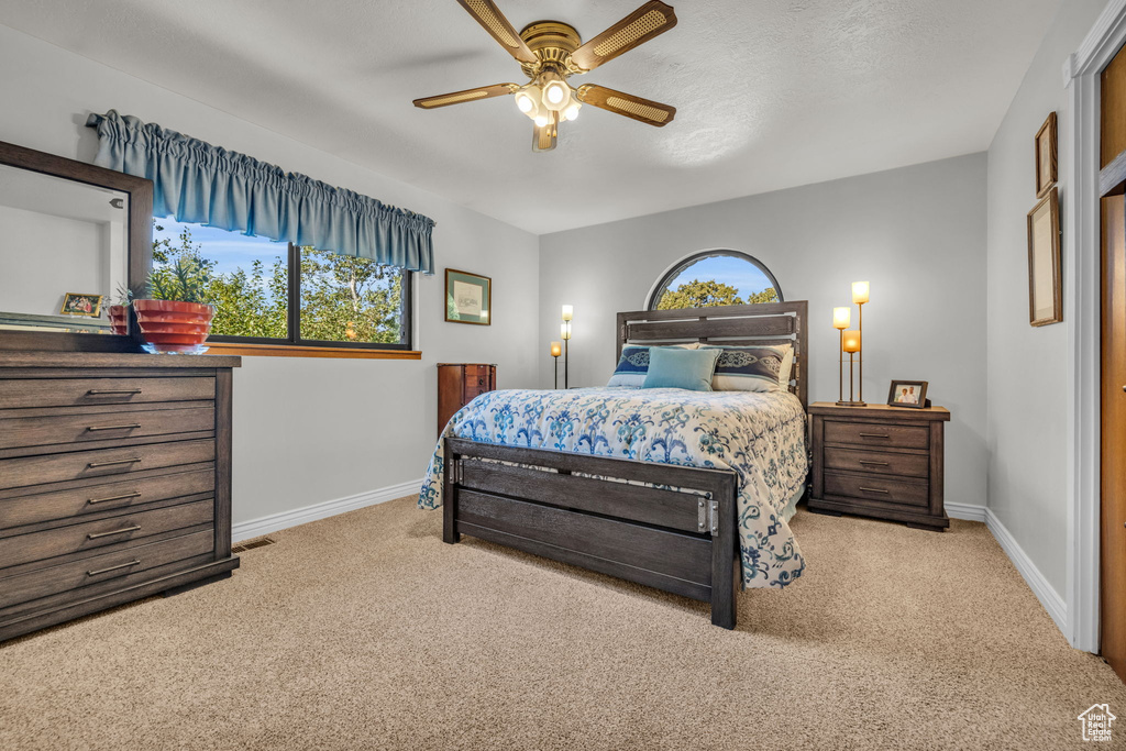 Carpeted bedroom featuring baseboards and a ceiling fan