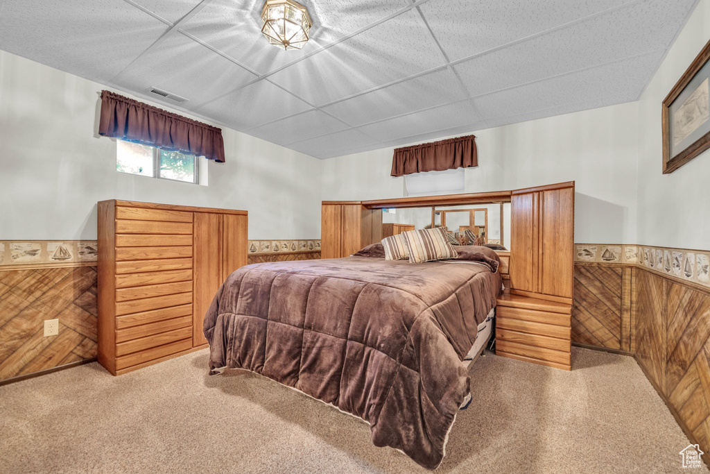 Carpeted bedroom featuring wainscoting