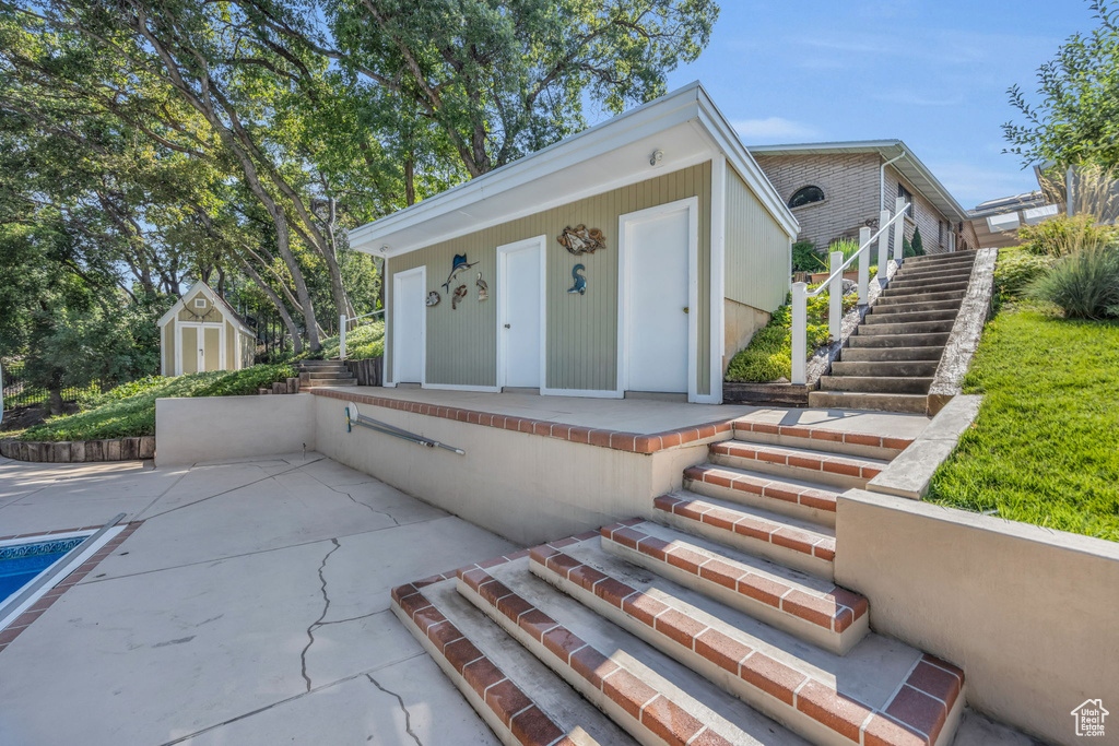 View of front of property featuring stairway and a patio
