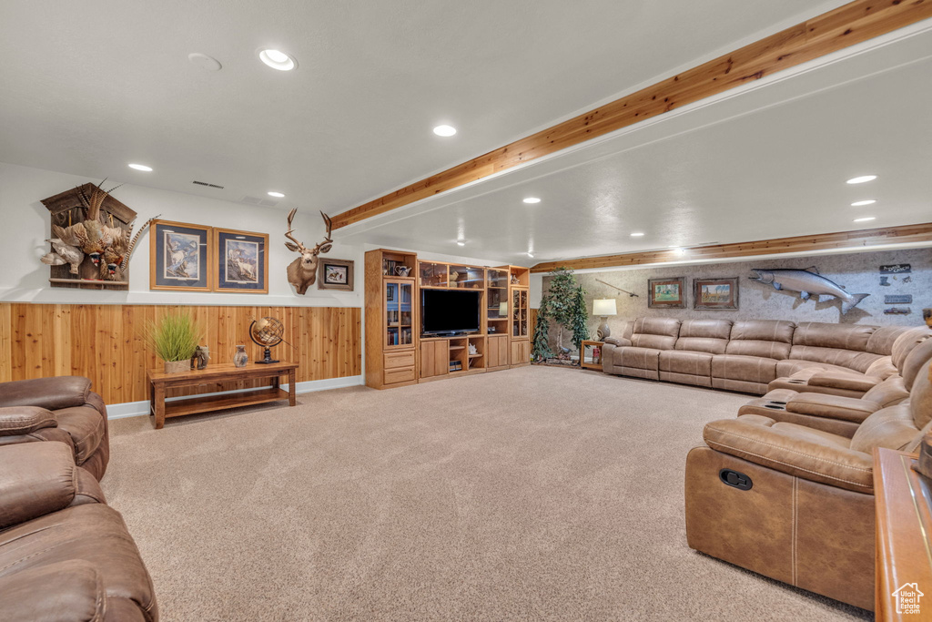 Living room with carpet floors, wood walls, recessed lighting, a wainscoted wall, and beam ceiling