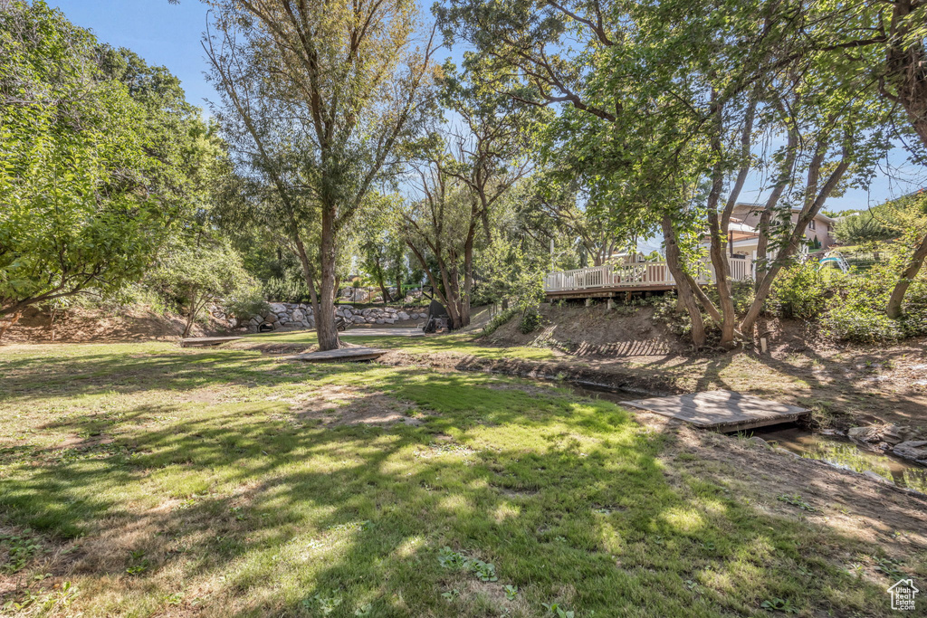 View of green lawn featuring a deck