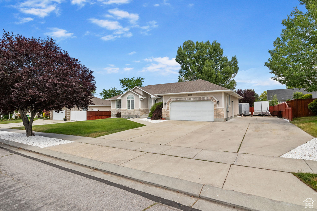 Single story home with an attached garage, concrete driveway, and a shingled roof