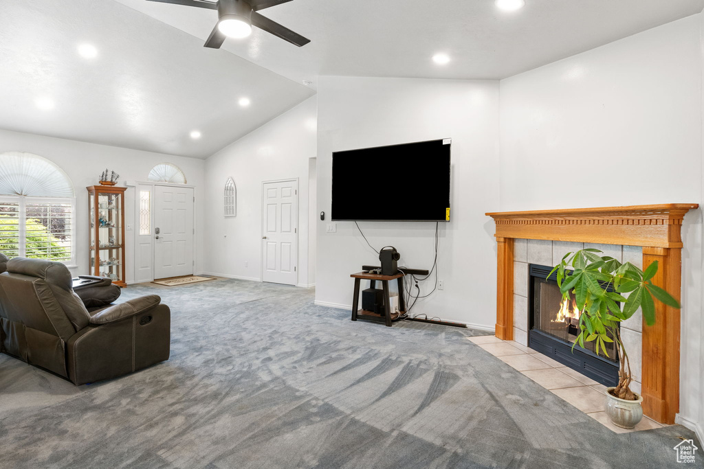 Living area featuring lofted ceiling, a tile fireplace, recessed lighting, a ceiling fan, and carpet floors