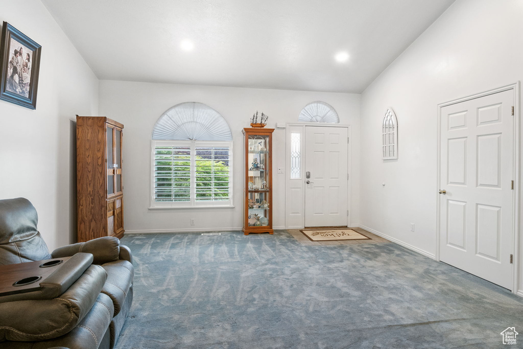 Foyer entrance with carpet floors and baseboards