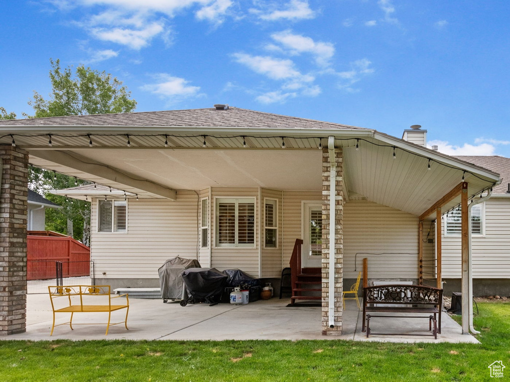 Back of house with a chimney, a patio area, entry steps, and roof with shingles