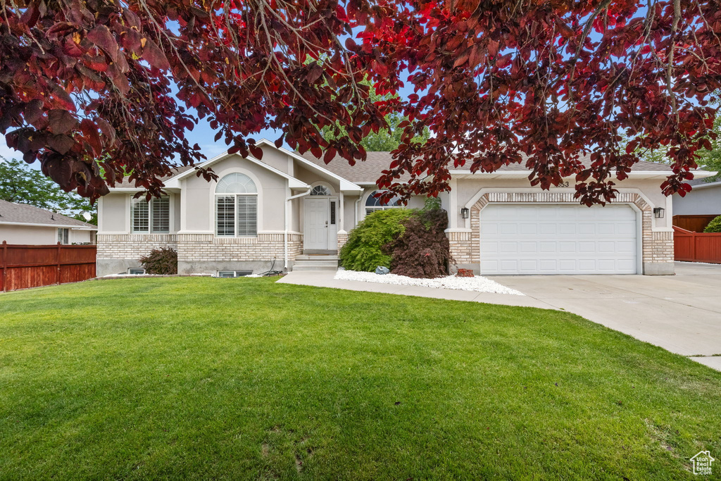 View of front of property with driveway, stucco siding, and an attached garage