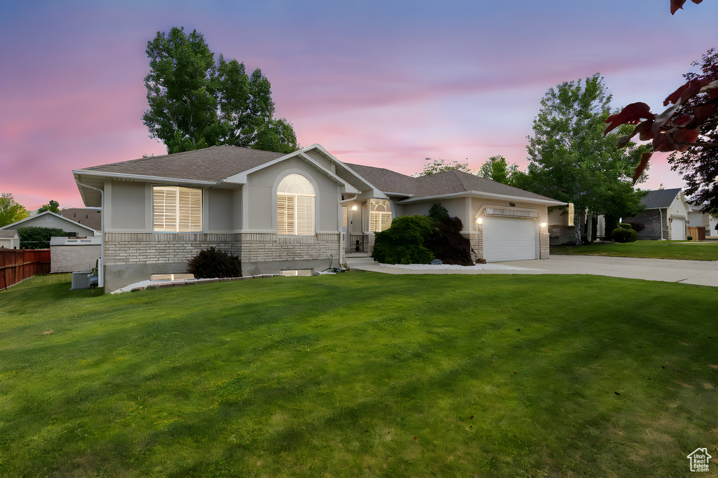 Ranch-style home featuring stucco siding, driveway, a garage, roof with shingles, and stone siding