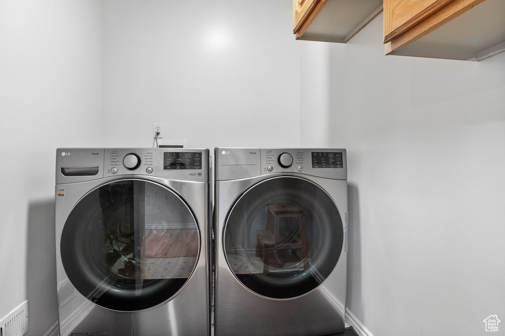 Washroom with cabinet space and washer and dryer